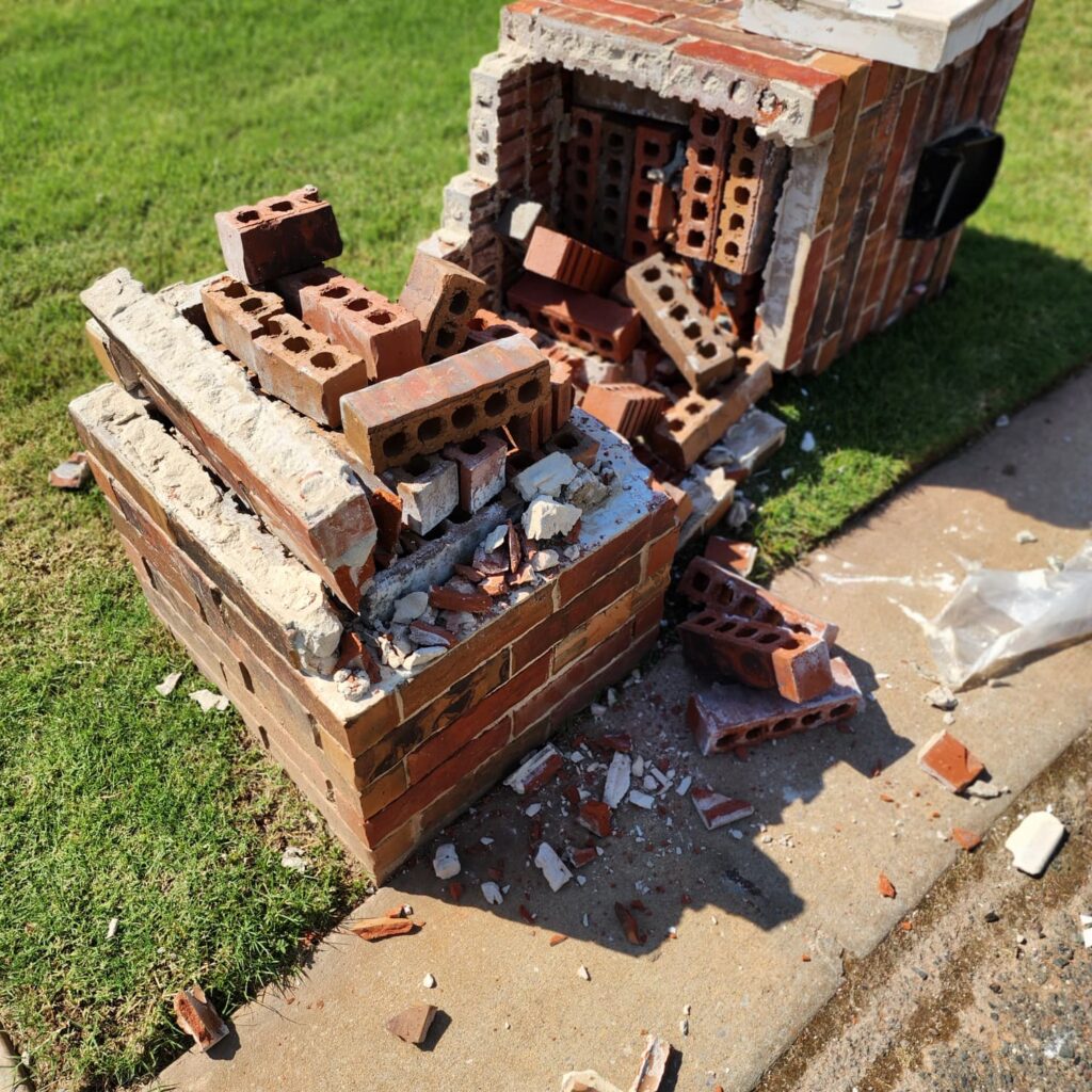 Close-up of damaged brick mailbox structure before rebuild