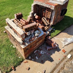 Close-up of damaged brick mailbox structure before rebuild